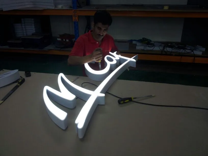 Lit polycarbonate lettering being assembled